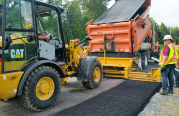 Road Widener loader attachment laying asphalt